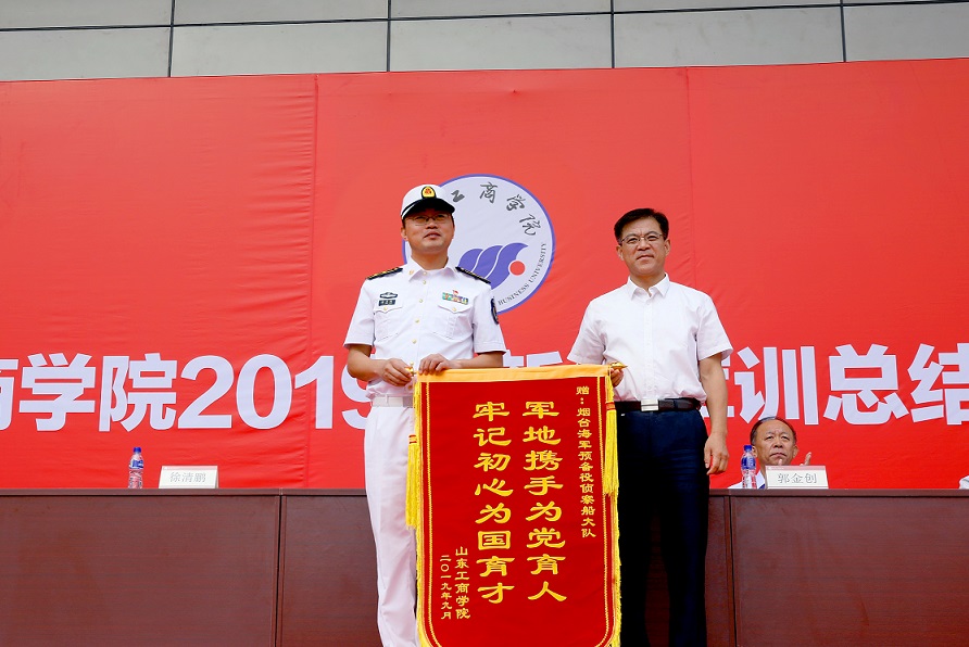 杨同毅代表学校向承训部队赠送锦旗。